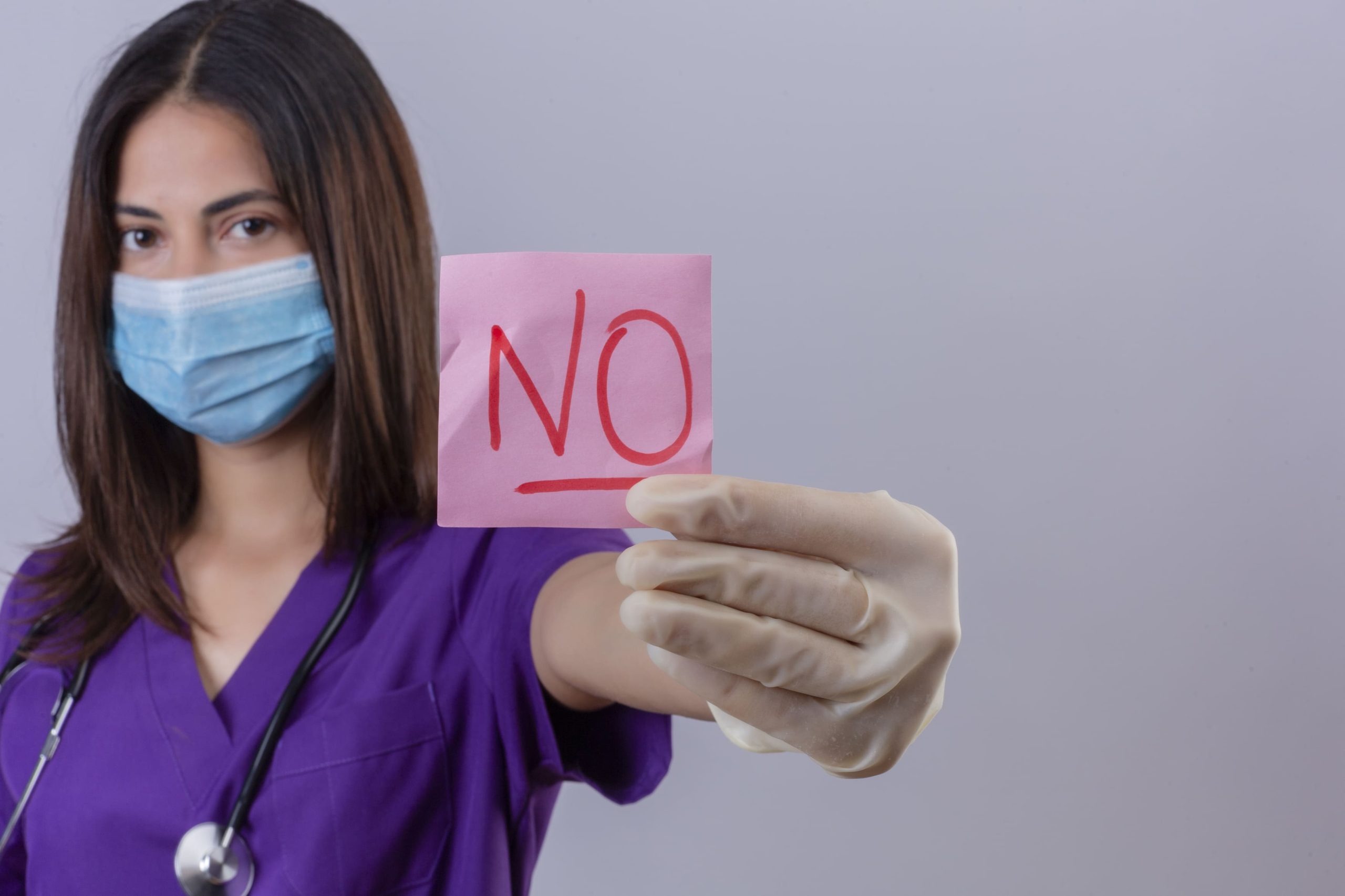 young-woman-nurse-wearing-medical-uniform-protective-mask-gloves-with-stethoscope-showing-reminder-paper-with-word-no-looking-confident-1-1-scaled.jpg