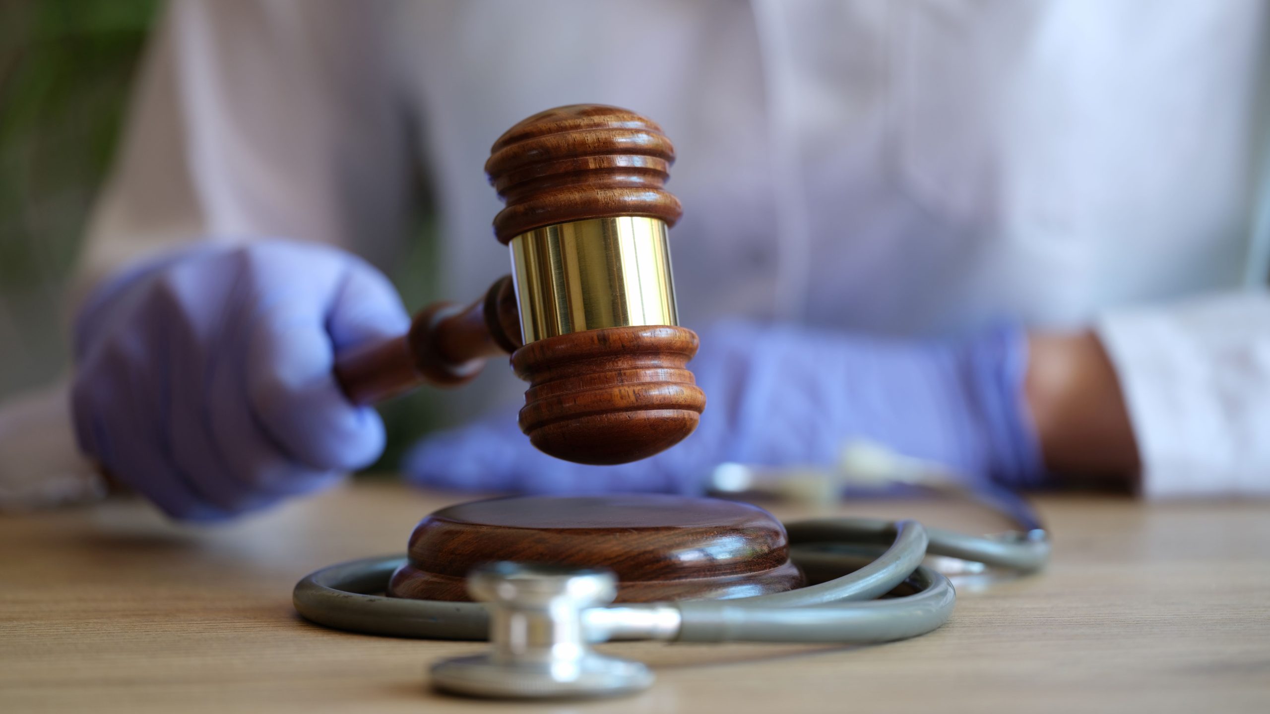 closeup-female-doctor-with-judge-gavel-medical-stethoscope-medical-litigation-verdict-2-scaled.jpg