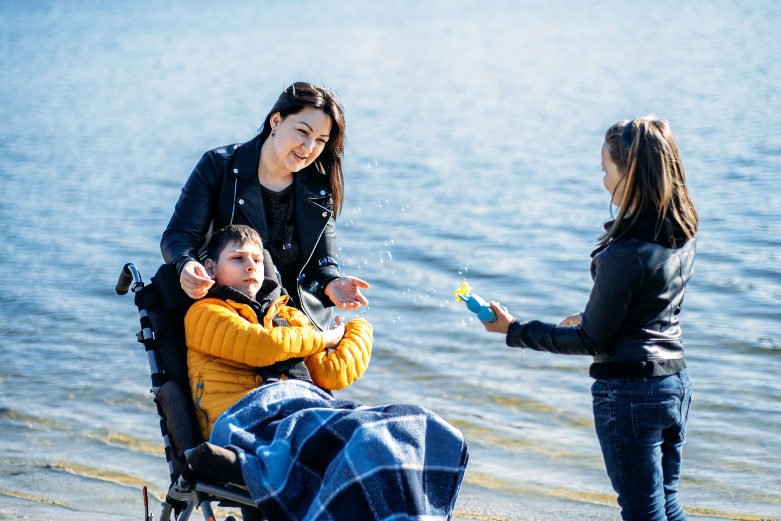 happy-family-mother-daughter-son-with-cerebral-palsy-spending-time-together-river-bank-2-scaled.jpg