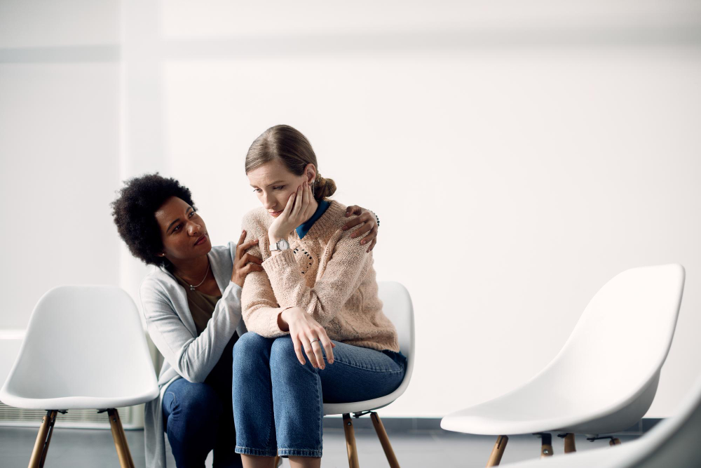 caring-african-american-woman-consoling-sad-woman-before-group-therapy-meeting.jpg