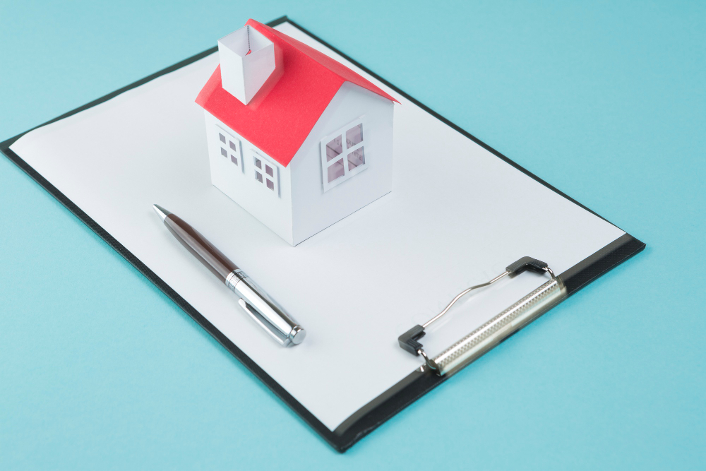 small-house-model-pen-blank-clipboard-blue-backdrop.jpg